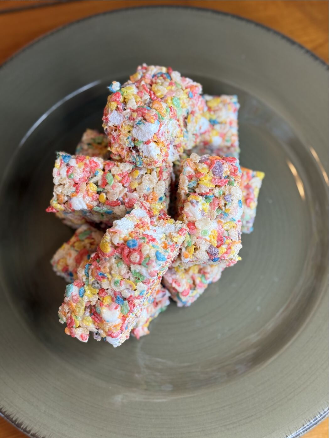 Fruity Pebbles Bliss Bites stacked on a plate.